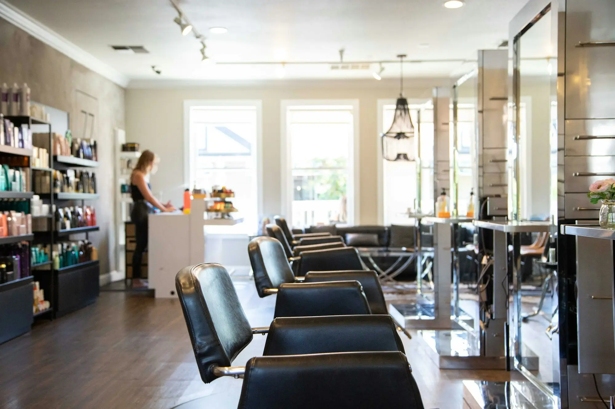 Hair salon owner standing by the styling chairs