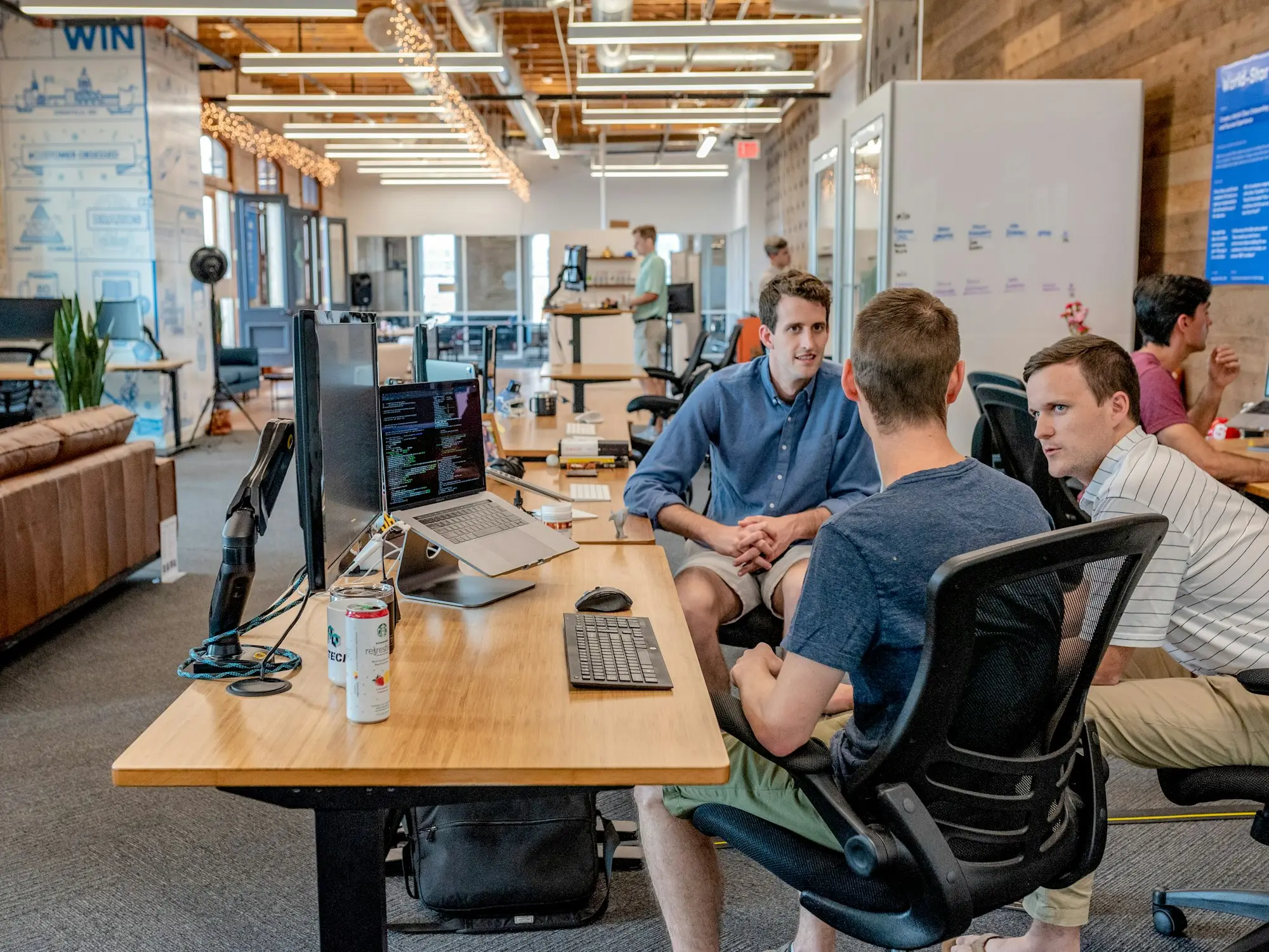 Three colleagues meeting around office tables